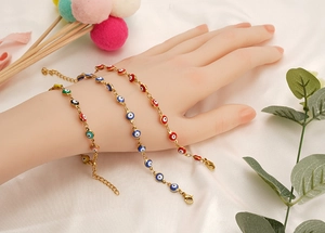 Detailansicht der Evil Eye Armbänder in Goldoptik mit blauen, roten und bunten Anhängern