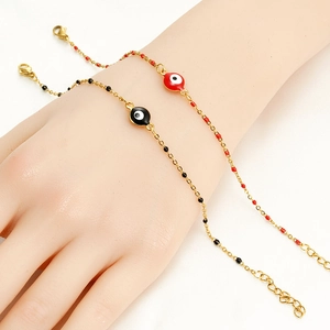 Dettaglio di bracciali in acciaio dorato 18K con perline smaltate Malocchio rosse e nere