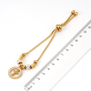 Détail du bracelet chaîne serpent en acier doré 18K avec pendentif croix en cristal