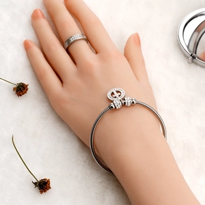 Silbernes Edelstahl Schlangenketten Armband mit Kreuzanhänger und Ring Set an Model