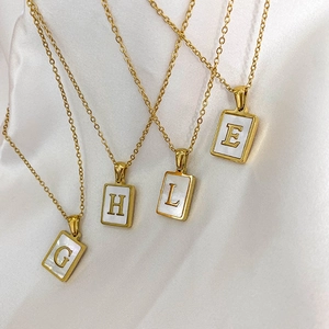 Gros plan de pendentifs rectangulaires dorés avec nacre sur tissu en soie blanche