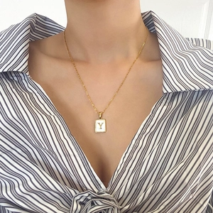 Collier minimaliste en or avec pendentif carré en nacre et lettre Y sur chemise
