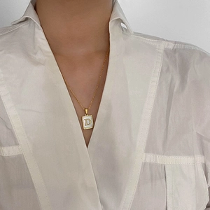 Collier minimaliste en or avec pendentif carré en nacre et lettre D sur chaîne fine