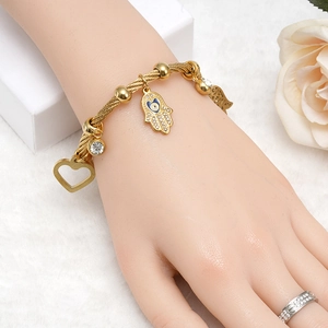 Bracciale rigido a treccia dorato con ciondoli Mano di Fatima e cuore con occhio blu