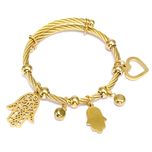 Dettaglio del bracciale a corda dorata con mano di Fatima, ciondoli a cuore e perle