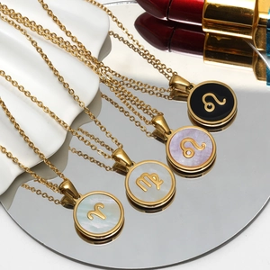 Detalle de collares de signos zodiacales bañados en oro 18K con nácar blanco