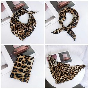Macro detail of silk-like leopard print scarf showing fine black hem and soft texture