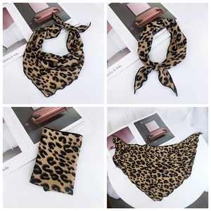 Detailed close-up of leopard print silk scarf with fine black hem on fashion magazine background