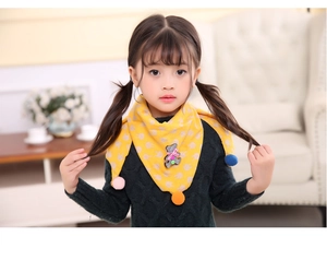 Detail of yellow cotton scarf for kids with rabbit print, felt bear patch and colorful pom-poms