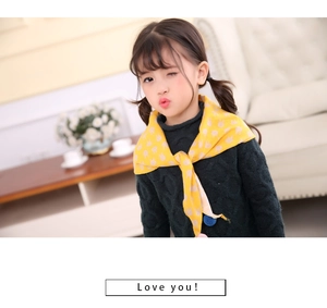 Close-up of kids yellow triangle scarf with rabbit print and blue pom-pom details