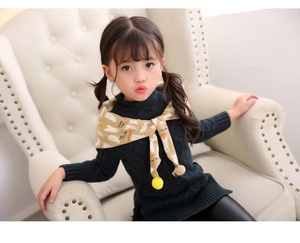 Close-up of child's polar bear print scarf with colorful tassels and knit sweater