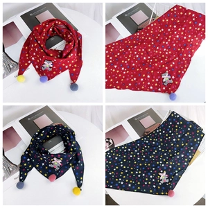 Detail of children's cotton star pattern triangle scarf with plush pom-poms and cute patch