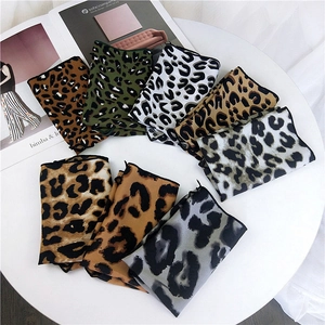 Multiple colorful leopard print satin neckerchiefs arranged on a white round display