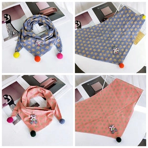 Detail of kids knit triangle scarf with cartoon rabbit prints and plush ball tassels