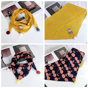 Detailed view of kids cotton triangle scarf with rabbit print and colorful pom-pom edges