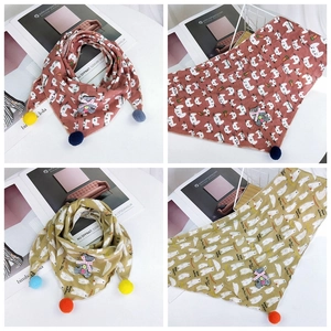 Detail of cotton baby triangle scarves with pom-poms and cute animal embroidery patches