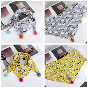 Detail of cotton kids triangle scarf with penguin print, tassels and bear patch