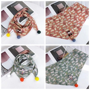 Detail of soft cotton kids triangle scarf with polar bear prints and colorful pom-poms