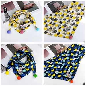 Detail of cotton kids triangle scarf with cute koala patch and colorful pom-poms