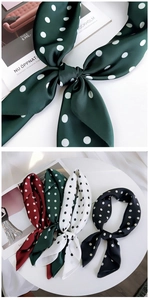 Close-up of elegant polka dot silk scarves in green, burgundy, black, and white colors