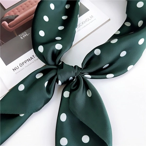 Elegant dark green polka dot silk scarf tied in a bow with high-quality satin sheen