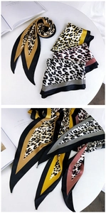 Detail of leopard print silk scarf texture with elegant glossy satin fabric finish