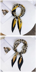 Detailed view of leopard print silk scarves with satin finish on a minimalist tabletop