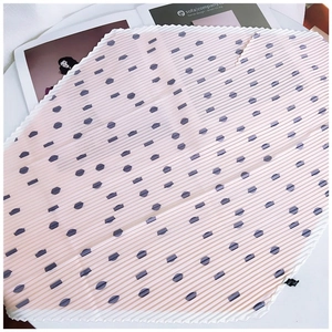 Close-up of pleated pink silk scarf with purple polka dots and fine rolled edges