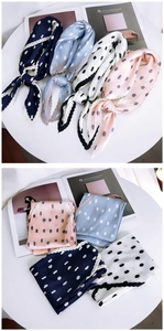 Close-up of pleated polka dot scarves in navy, blue, cream, and pink for women