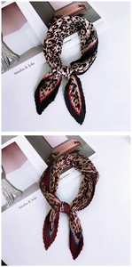 Detail of pleated skinny scarves with leopard patterns in black, red, and brown tones