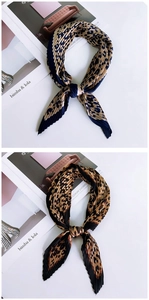 Detail of pleated silk scarves featuring leopard print patterns in navy and brown
