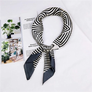 Detail of a black and white geometric silk scarf with professional satin finish texture
