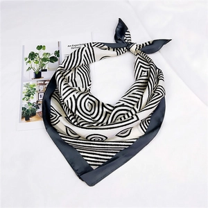 Close-up of black and white geometric stripe silk scarf with soft luster on white fabric