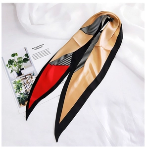 Detail of color-block silk scarf with geometric diamond patterns on white fabric