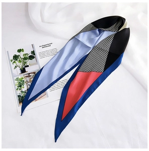 Detailed view of a geometric silk twilly scarf with red blue and black striped patterns