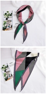 Macro detail of geometric color-block silk scarf with fine stitching on white fabric