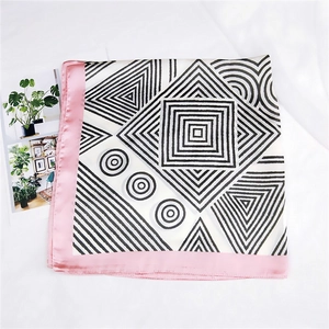 Detail of square silk scarf with black white geometric patterns and pink edges