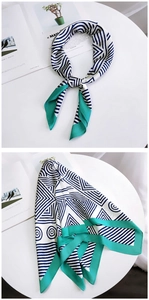 Detail of navy striped silk scarf with vibrant green border on a white desk