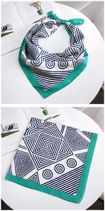 Macro view of geometric pattern silk scarf with navy lines and vibrant green borders