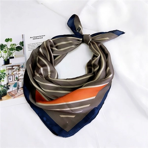 Detail of diagonal striped silk scarf with orange accent and luxury fabric texture