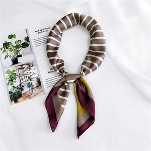 Detailed view of silk-like neckerchief with striped patterns on a soft fabric texture