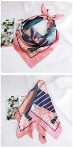 Détail du foulard en soie à imprimé géométrique noué sur un tissu texturé blanc