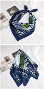Détail du foulard en soie géométrique bleu et vert montrant les motifs contrastés