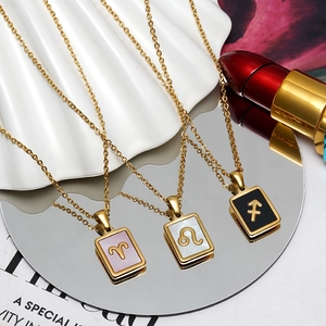 Detailed shot of 18K gold plated zodiac necklaces with shell inlay on a stylist mirror base