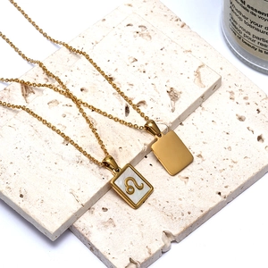 Macro detail of 18K gold Leo zodiac pendant with white mother of pearl inlay on stone