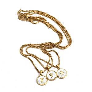 Detail of 18K gold-plated stainless steel shell initial necklaces with F, P, B pendants