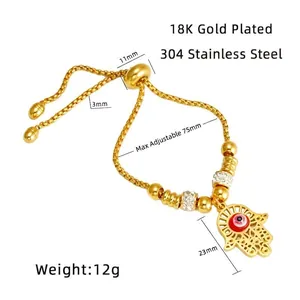 Detail of 18K gold plated stainless steel Hamsa Hand bracelet with red evil eye charm