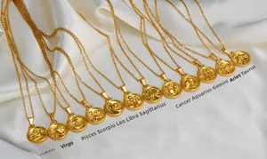 Collection de 12 pendentifs zodiaque en or 18K disposés sur un tissu de soie blanc