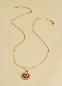 Détail du collier Mauvais Œil doré montrant l'émail rouge et le fermoir mousqueton