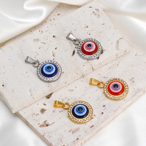 Gros plan de pendentifs mauvais œil avec montures or et argent et strass incrustés